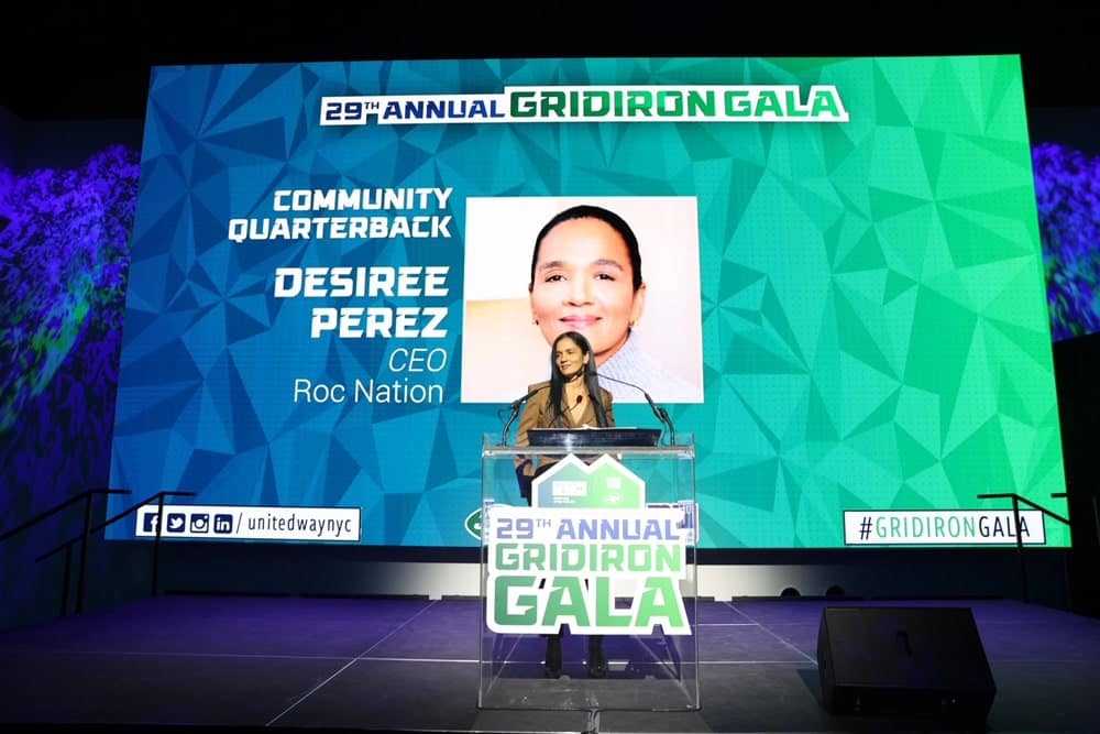 Desiree Perez, Roc Nation CEO, stands on stage at the 29th Annual Gridiron Gala to accept the Community Quarterback Award